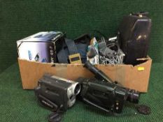 A box of manual typewriter, assorted cameras, Sat Nav,