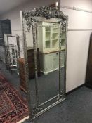 A tall ornate panelled mirror