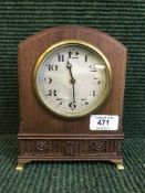 A mahogany mantel clock on brass bracket feet