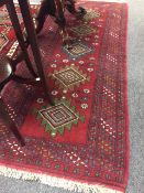 A fringed Persian rug on red ground