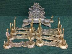 A tray of brass coat hooks and a decorative brass desk stand