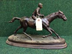 A bronze figure of a horse and jockey
