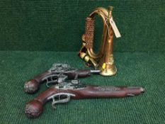 A brass and copper military bugle and two reproduction flint lock pistols