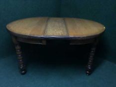 An early 20th century wind out dining table