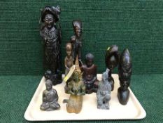 A tray of carved hardwood eastern and tribal figures, pottery figure Japanese warrior,