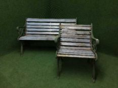 A wrought iron and wooden garden bench with matching chair