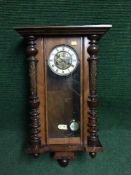 An Edwardian mahogany wall clock with pendulum and key