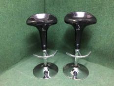 A pair of black and chrome gas lift bar stools