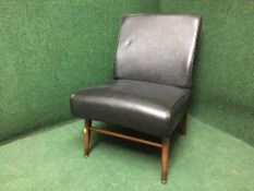 A mid twentieth century black vinyl chair on teak legs