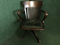An Edwardian oak leather seated armchair