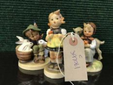Three Hummel figures - boy with rabbits etc