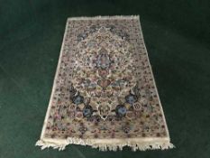 A floral fringed woolen rug on cream ground
