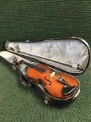 A violin in shaped case with bow