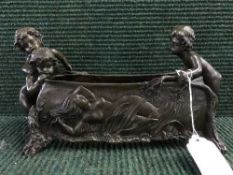 A bronze planter modelled with three cherubs and with embossed decoration to sides depicting