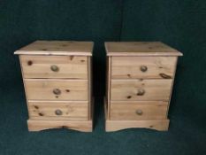 A pair of pine three drawer bedside chests
