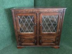 An oak leaded glass door bookcase