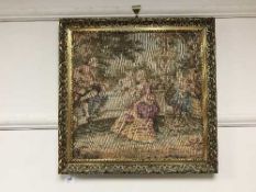 A gilt framed tapestry depicting figures in a garden