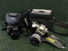 A cased Nikon D 50 camera with lens and Olympus IS-1000 camera