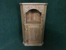 A pine single door corner cupboard