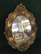 An oval gilt framed cherub mirror