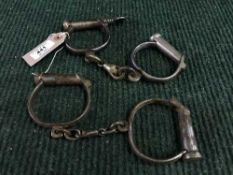 Two pairs of late 19th century metal handcuffs (one with key)