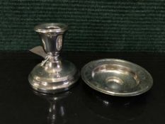 A silver dwarf candlestick together with a silver pin dish
