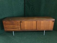 A mid twentieth century Danish teak sliding door low sideboard
