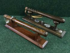 Two wooden Police truncheons on stands