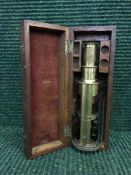 A small brass microscope in fitted mahogany box