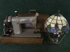 A walnut cased Singer sewing machine together with a Tiffany style table lamp