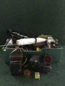 A box of cameras, equipment including tripods, flashes, parasols, cameras by Voightlander,