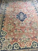 A large fringed floral carpet on salmon ground