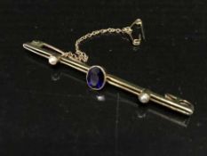 A 15ct gold bar brooch inset with amethyst and seed pearl