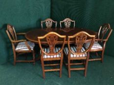 An inlaid twin pedestal dining table with leaf and six shield back chairs