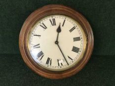 A circular oak school clock with battery movement