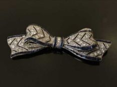 A fine white gold, diamond and sapphire set bow brooch,