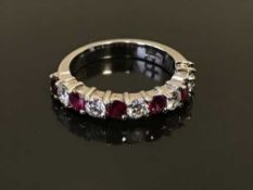 An 18ct white gold ruby and diamond half eternity ring