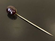A gold and cabochon garnet stick pin, 5.