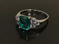 An 18ct white gold emerald and diamond cluster ring