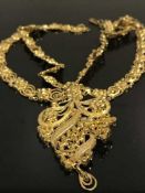 A highley ornate yellow gold chain necklace, with pendant drop in textured gold, stamped 22C, 64.4g.