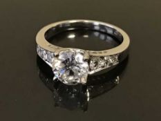 An 18ct white gold diamond ring, the principal brilliant cut stone within a claw setting,