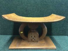 A carved hardwood tribal headrest