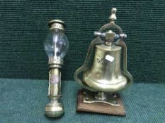 A brass bell on stand bearing the name Davila and a brass White Star wall light