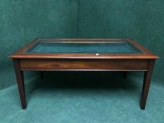 A mahogany glass topped curio coffee table