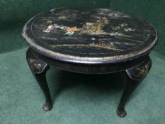 A circular oriental black lacquered coffee table