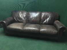 A contemporary brown leather three seater settee