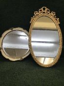 An oval gilt framed mirror together with a cream and gilt circular framed mirror
