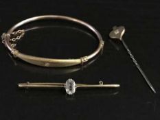 An antique 9ct gold bangle set with a diamond,