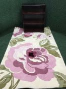 A contemporary cream floral rug together with a set of mahogany open bookshelves