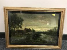 A gilt framed oil on canvas depicting a cottage in marshland indistinctly signed